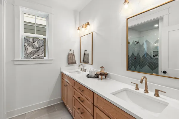 a bathroom with double vanity sink and two mirror