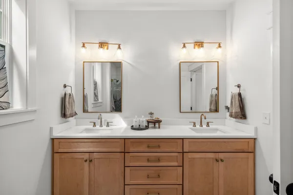 a bathroom with double vanity sinks and a mirror