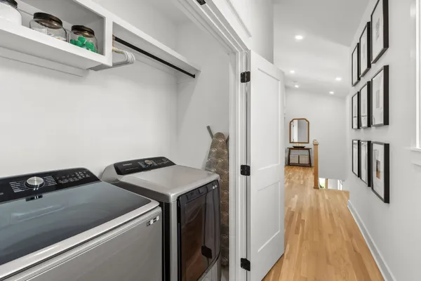 a hallway view with wooden floor and electronic appliances