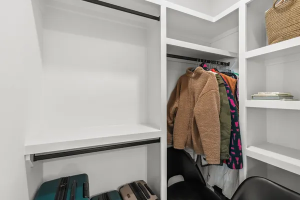 a view of walk in closet with clothes and shoes