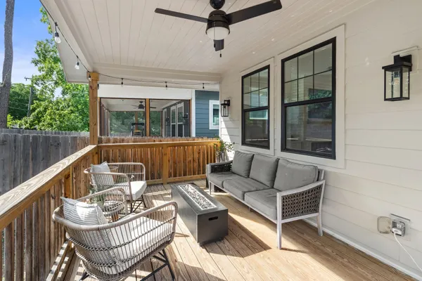 a view of a patio with couches chairs and wooden floor