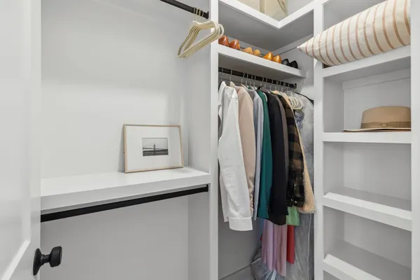 a view of walk in closet with clothes and shoes