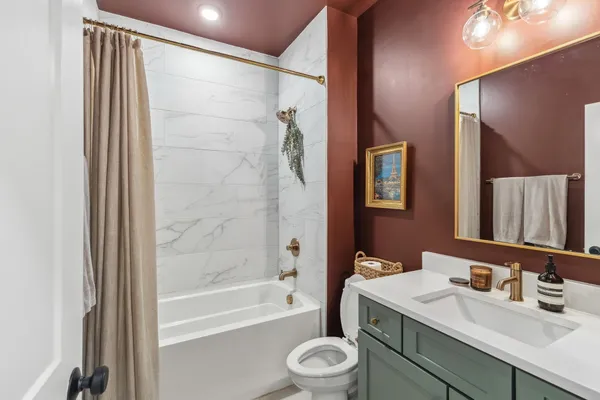 a bathroom with a sink a toilet a mirror a vanity and bathtub