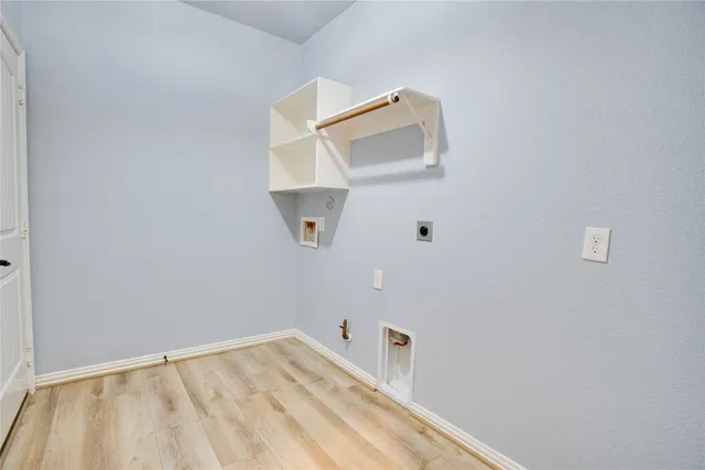 an empty room with a white wall and sink