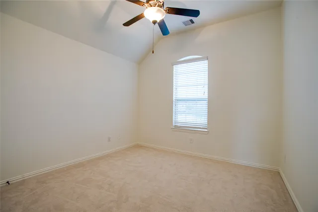 an empty room with a window and a fan