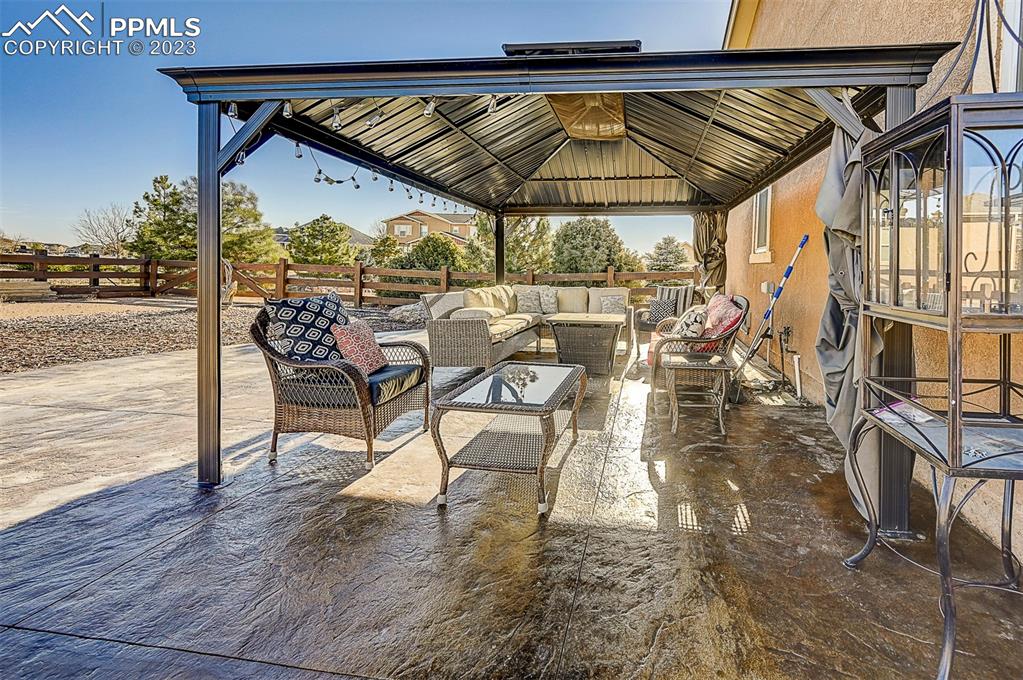 7555 Antelope Meadows Circle Peyton, CO 80831 - Photo 2 of 7 a patio with wooden floor a yard a table and chairs