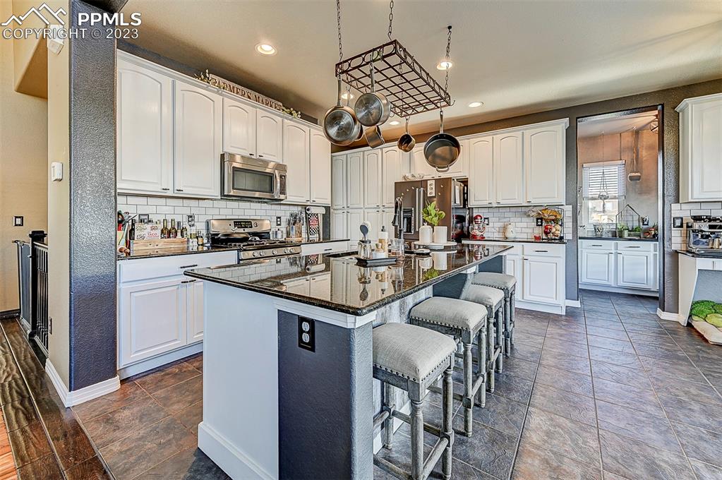 7555 Antelope Meadows Circle Peyton, CO 80831 - Photo 6 of 7 a kitchen with stainless steel appliances kitchen island granite countertop a sink and cabinets