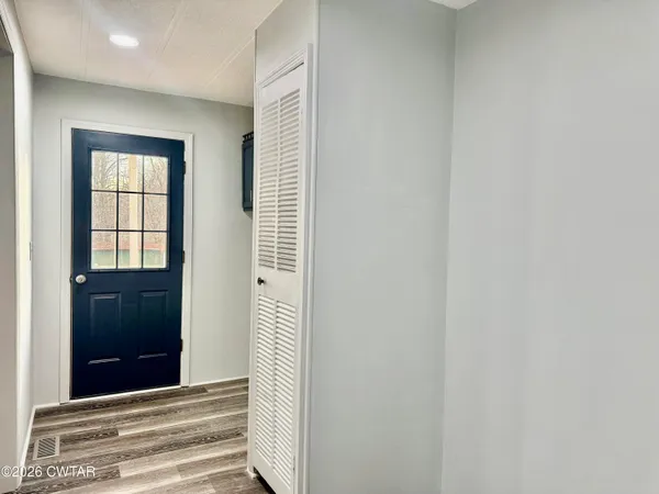a view of a hallway with wooden floor and windows