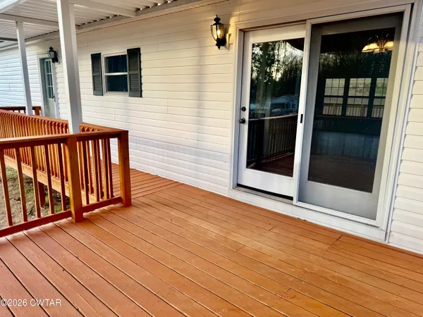 a view of a balcony with wooden floor and floor to ceiling window