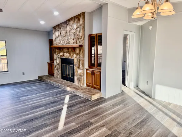 a view of a livingroom with wooden floor and a fireplace