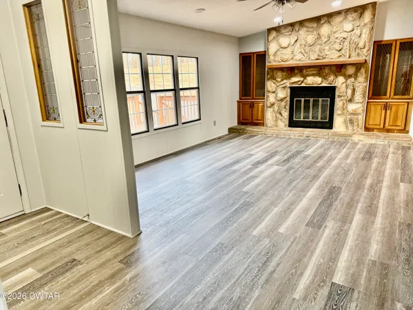 a view of an empty room with a window and fireplace