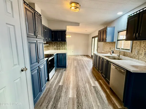 a kitchen with stainless steel appliances granite countertop a refrigerator a stove a sink and a microwave