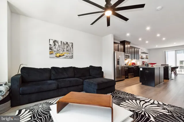 a living room with furniture kitchen view and a window