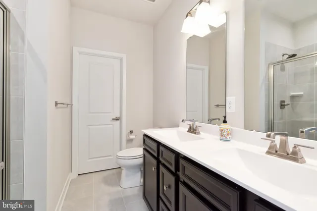 a bathroom with a sink a toilet and a large mirror