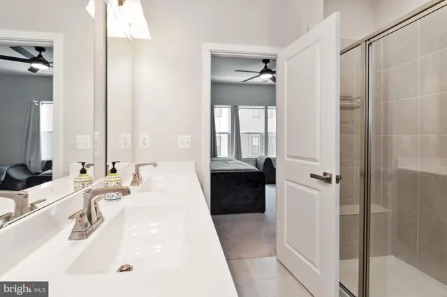 a en suite bathroom with a double vanity sink a mirror and a bathtub