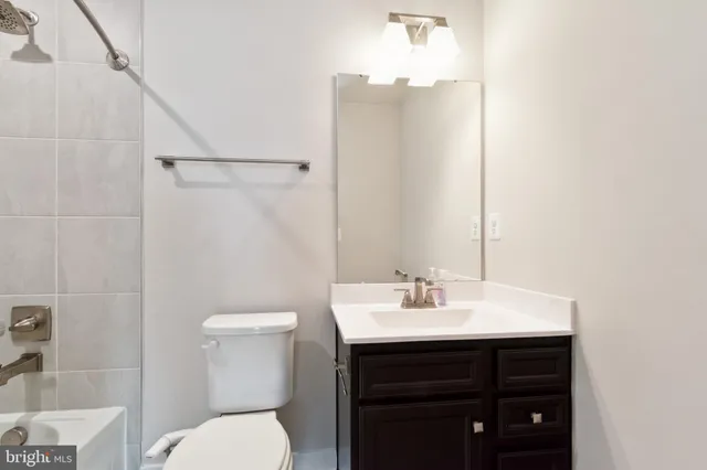 a bathroom with a sink vanity mirror and toilet
