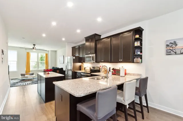 a kitchen with granite countertop a sink and chairs