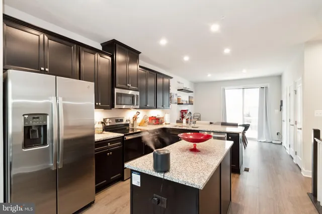 a kitchen with stainless steel appliances granite countertop a sink stove and refrigerator