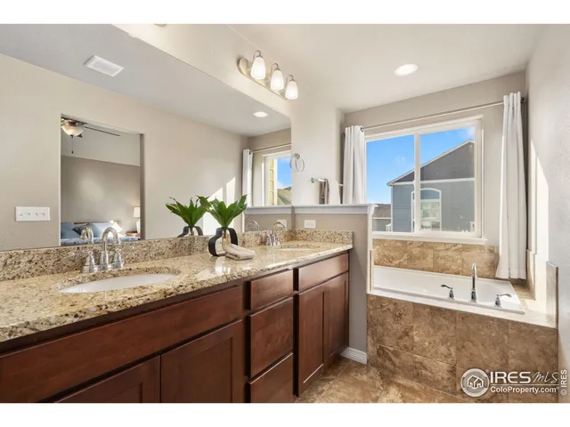 a bathroom with a granite countertop sink mirror and bathtub