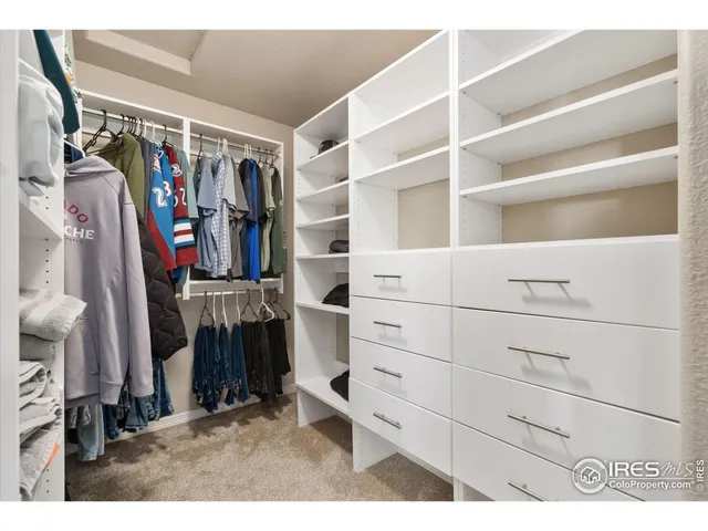 a view of walk in closet with clothes and shoes