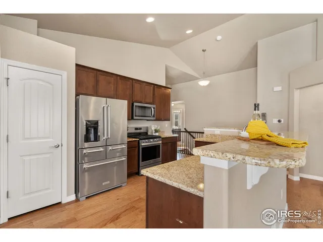 a kitchen with a sink a kitchen island and stainless steel appliances