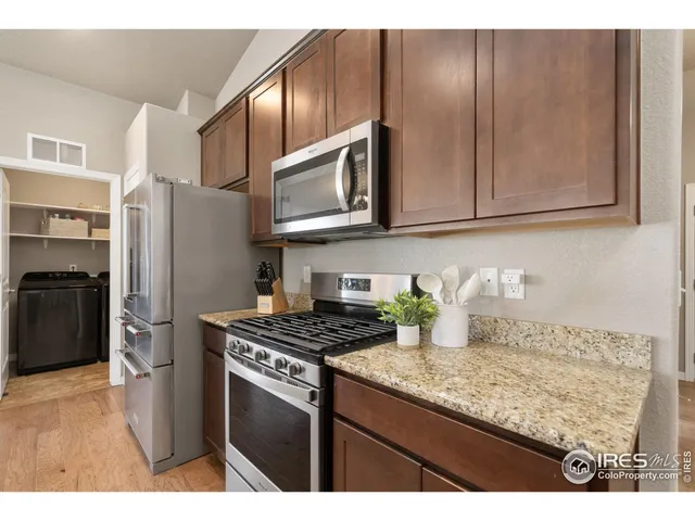 a kitchen with granite countertop cabinets stainless steel appliances and a counter space