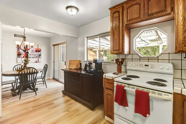 a kitchen with stainless steel appliances granite countertop a stove a sink and a dining table