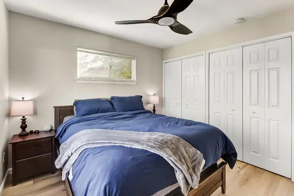 a spacious bedroom with a bed and wooden floor