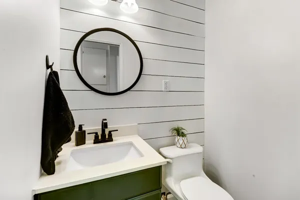a bathroom with a toilet a sink and a mirror