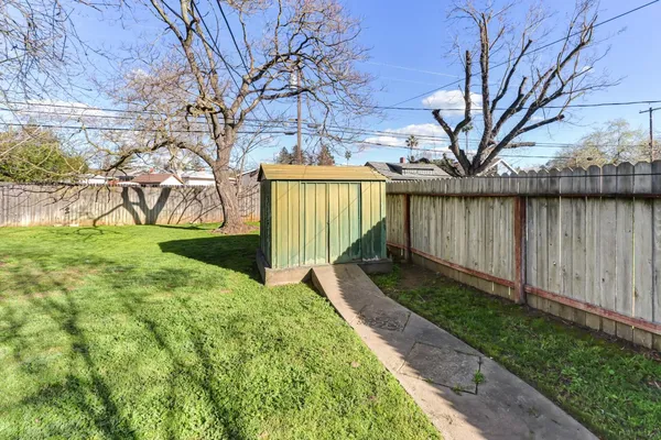 a view of a backyard with wooden fence