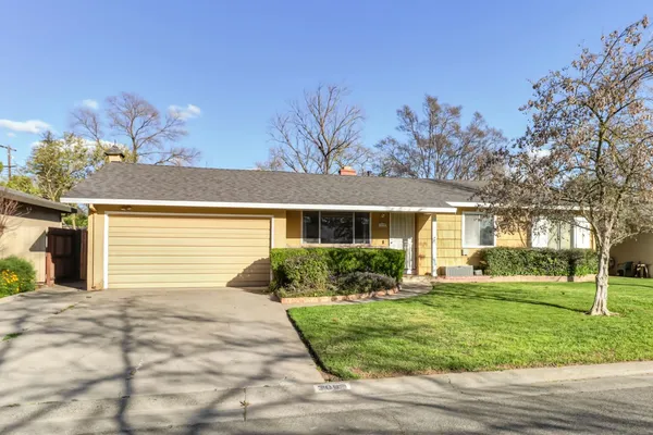 a front view of a house with a yard and potted plants