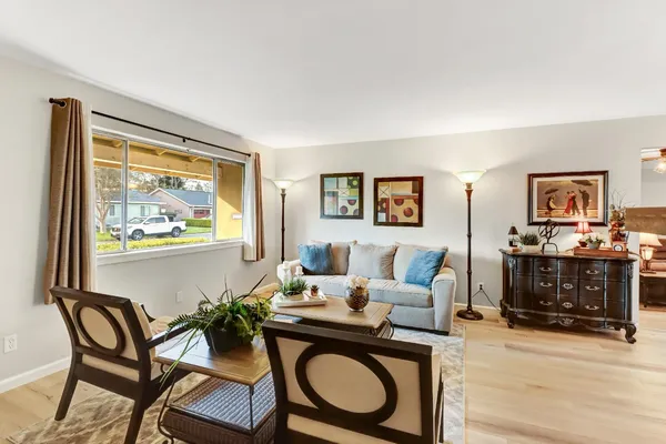 a living room with furniture a large window and a fireplace