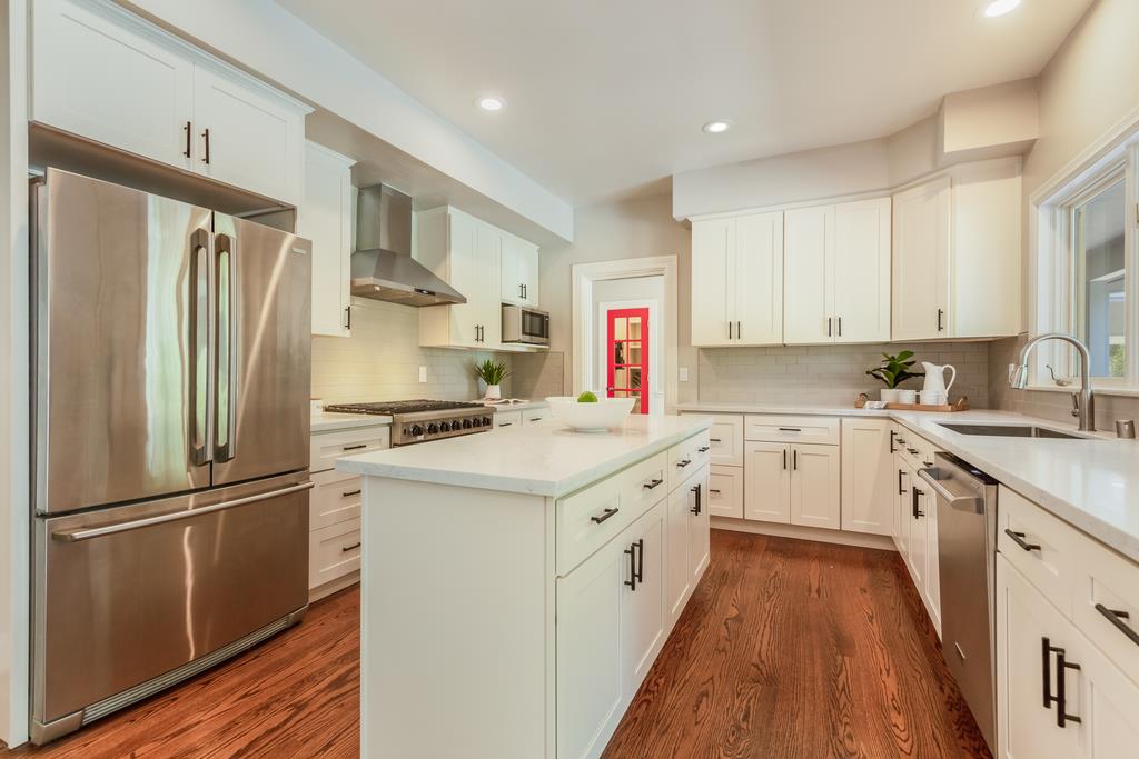 12385 Parker Ranch Road Saratoga, CA 95070 - Photo 19 of 50 a kitchen with granite countertop a refrigerator a sink dishwasher a stove and white cabinets with wooden floor
