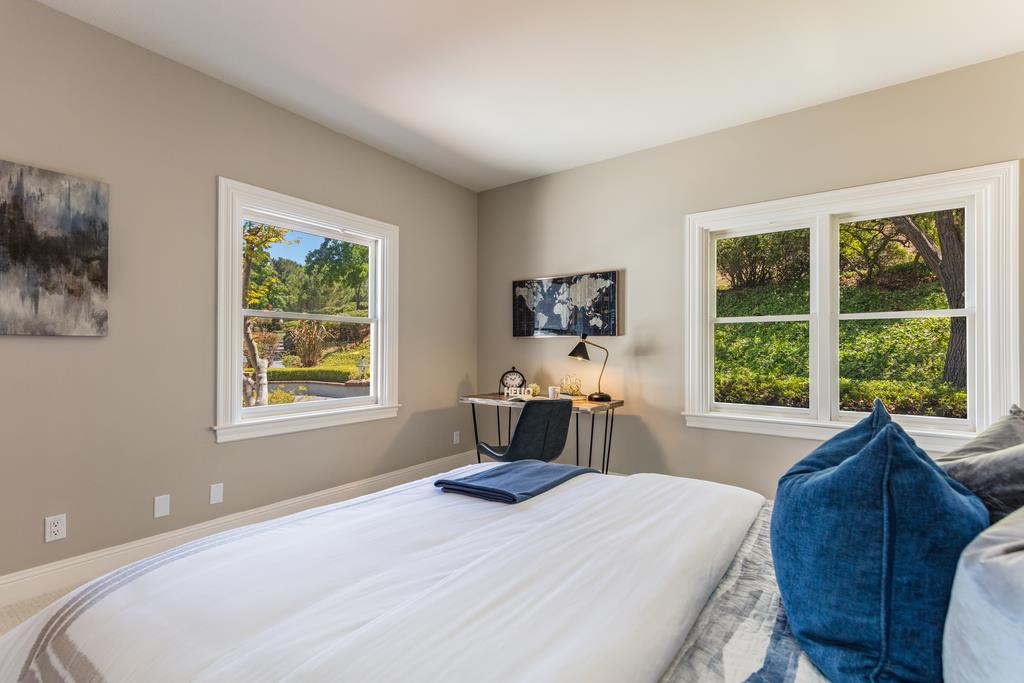 12385 Parker Ranch Road Saratoga, CA 95070 - Photo 38 of 50 a bedroom with a bed a large window with table and chair