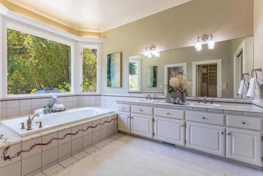 12385 Parker Ranch Road Saratoga, CA 95070 - Photo 47 of 50 a bathroom with a sink mirror and a bathtub next to a window