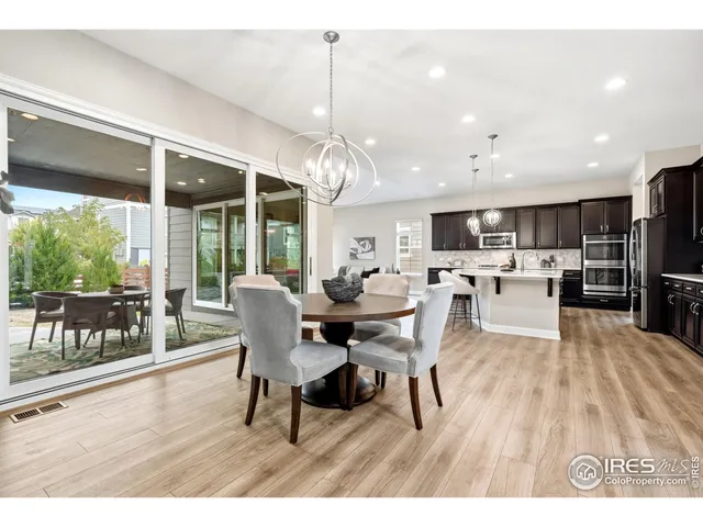 a view of a dining room and livingroom with furniture wooden floor a chandelier