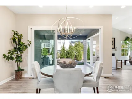 a dining room with furniture a chandelier and wooden floor
