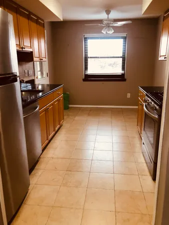 a kitchen with granite countertop a stove a sink and a refrigerator