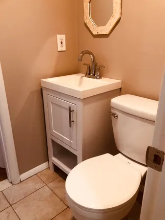 a bathroom with a sink a toilet and a mirror