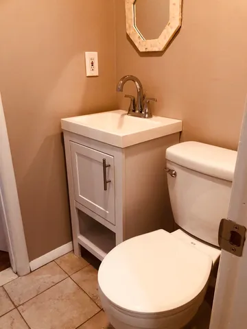 a bathroom with a sink a toilet and a mirror