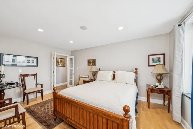 a bedroom with a bed a table and painting on the wall