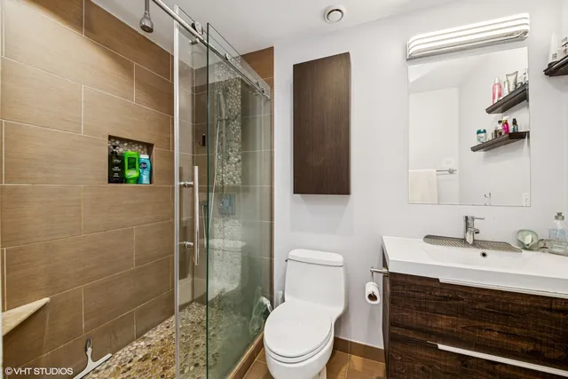 a bathroom with a sink mirror toilet and shower
