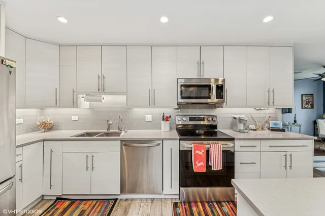 a kitchen with stainless steel appliances granite countertop a stove top oven a sink dishwasher and a refrigerator with the cabinets