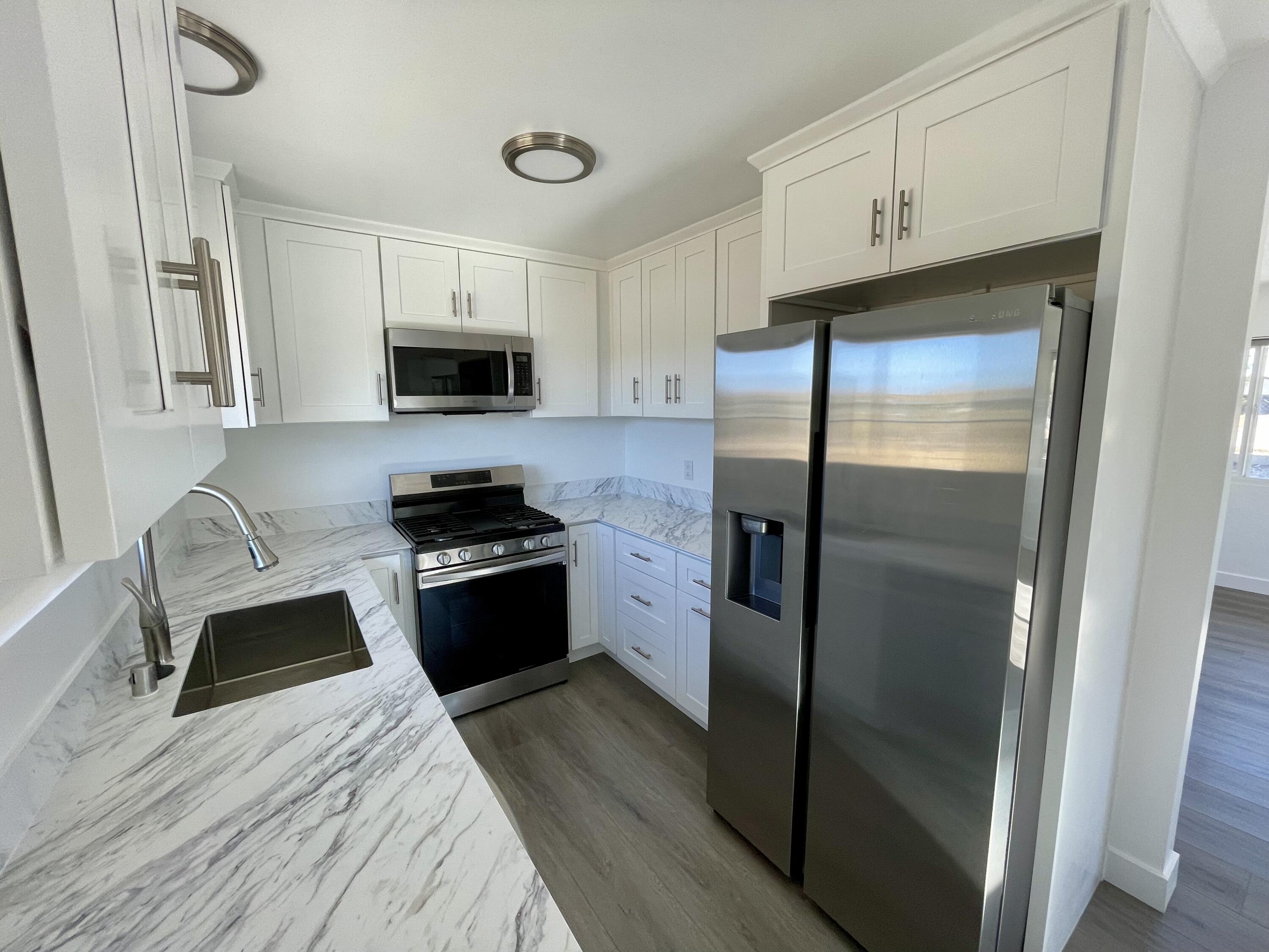 61880 Verbena Road Joshua Tree, CA 92252 - Photo 6 of 20 a kitchen with granite countertop a refrigerator stove and microwave