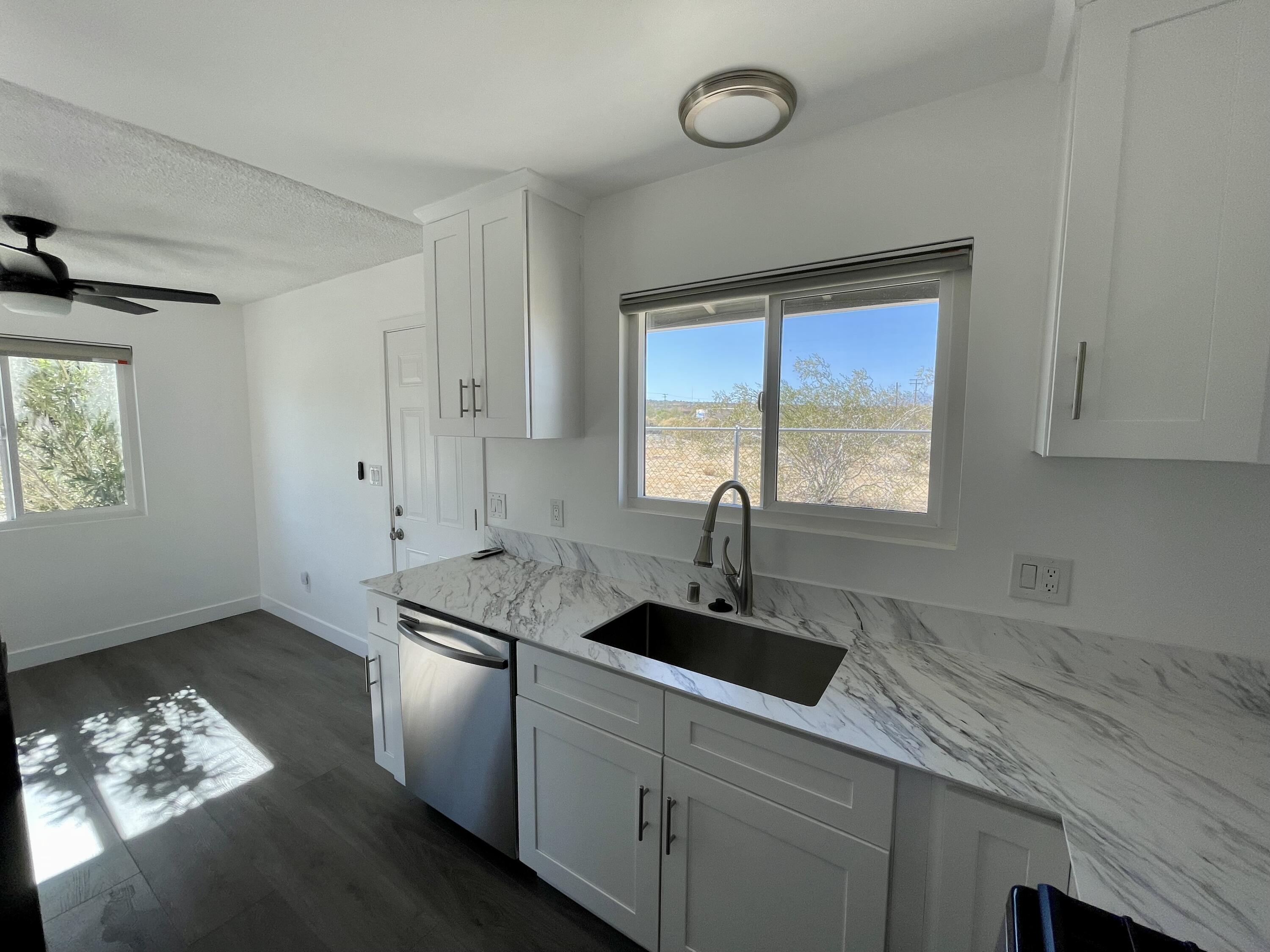 61880 Verbena Road Joshua Tree, CA 92252 - Photo 8 of 20 a kitchen with stainless steel appliances granite countertop a sink stove and cabinets