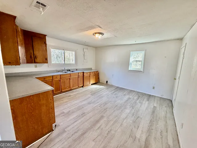 a view of a kitchen with wooden floor and a sink