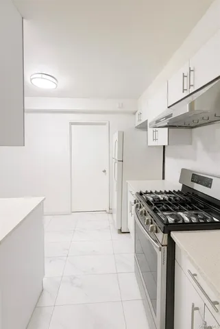 a kitchen with stainless steel appliances a stove a refrigerator and wooden cabinets