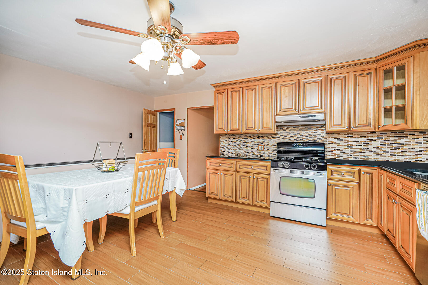33 Ebey Lane Staten Island, NY 10312 - Photo 6 of 23 a kitchen with granite countertop stainless steel appliances a stove top oven a sink dishwasher and white cabinets with wooden floor