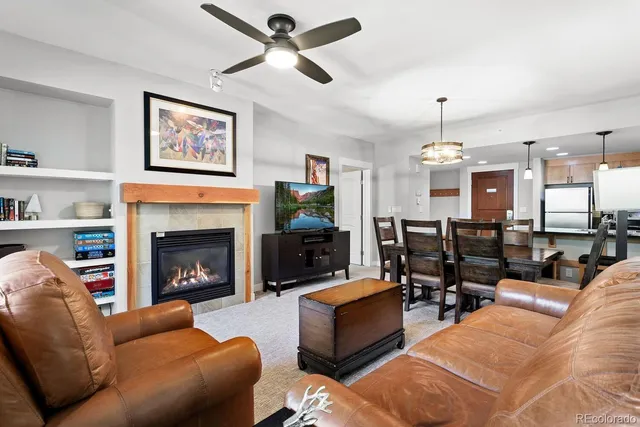 a living room with furniture ceiling fan and a fireplace