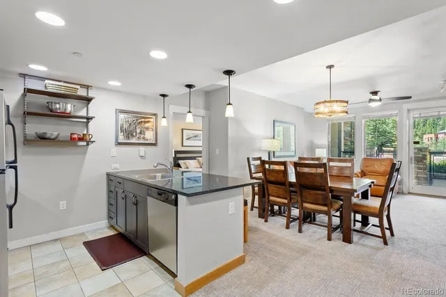 a kitchen with stainless steel appliances granite countertop a stove and a dining table
